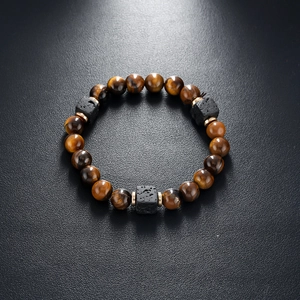 Detailed shot of brown tiger eye beads and black volcanic rock squares on a beaded bracelet