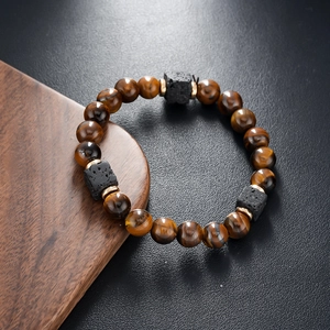 Macro detail of brown tiger eye beads and black lava stones with gold metal spacers