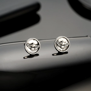 Polished silver eagle stud earrings featuring detailed eagle relief on black mirror background
