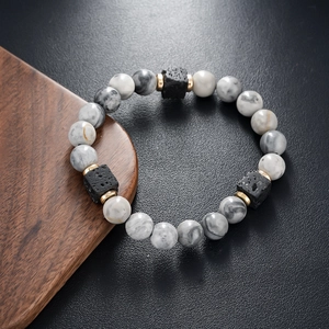 Macro shot of natural marble beads and black lava stone on textured leather background
