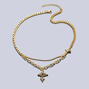 Detailed close-up of gold titanium cross pendant with black enamel and Cuban link chain