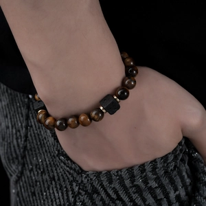 Detail of men's beaded bracelet with brown tiger eye stone and black lava rock