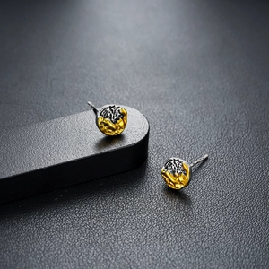 Close-up of dual-tone irregular studs with gold and oxidized silver texture detail