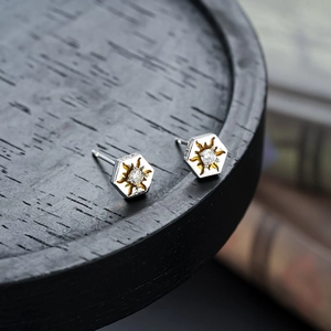 Macro shot of hexagonal sun stud earrings with gold plating and clear zircon inlay