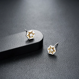 Macro detail of hexagonal sun stud earrings with S925 engraving and zircon inlay