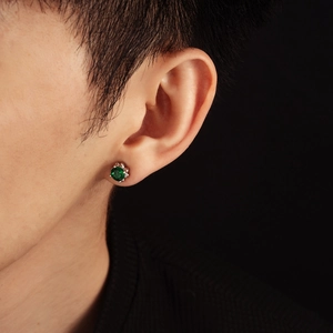 Macro shot of 4-prong set green zircon stud earring with polished silver metal finish