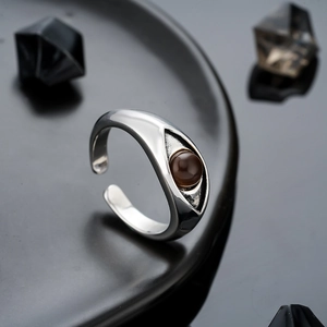 Vintage Eye of Horus open ring with brown stone inlay on a minimalist black display