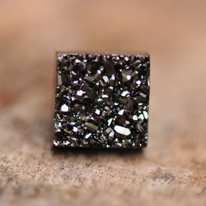 Dettaglio ravvicinato di orecchino magnetico quadrato con cristalli druzy grigio scuro