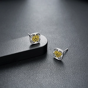 Retro square silver studs with yellow lotus design on premium black background