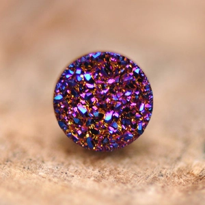 Macro di una pietra druzy tonda cangiante con trame di cristallo viola e blu scuro