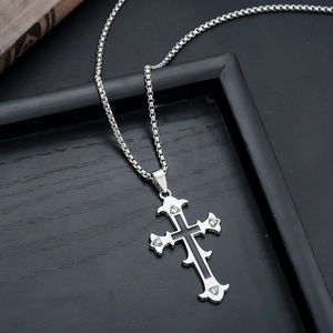 Detail of silver cross pendant with black inlay and rhinestones on a box chain