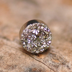 Macro di orecchino magnetico druzy argento su una superficie in legno rustico