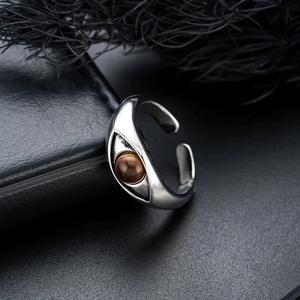 Macro shot of eye-shaped vintage copper ring with brown gemstone on black leather