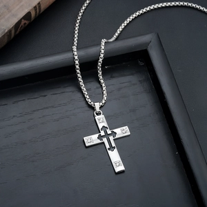 Macro view of silver cross pendant with black inlay and four clear rhinestones