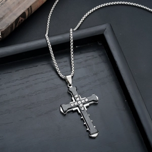 Detail of cross pendant necklace featuring black enamel inlay and sparkling zircon stones