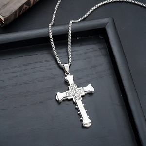 Macro detail of silver cross necklace with inlaid rhinestones and retro metal texture