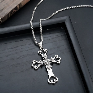 Detailed macro view of silver cross pendant with white zircon stones on a box chain