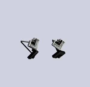 Detail of geometric V-shaped earrings with silver frame and black and white enamel inlays