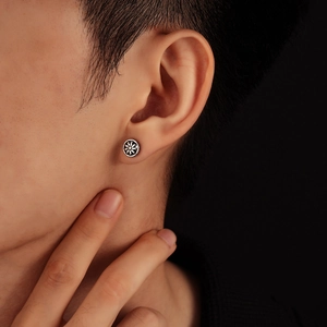 Retro silver sunburst stud earrings for men with oxidized vintage finish on model ear