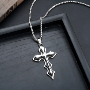 Close-up of gothic silver cross necklace with black enamel inlay on dark vintage background