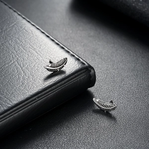 Vintage feather stud earrings in titanium steel with detailed retro oxidation finish