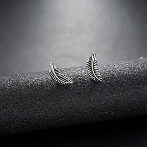 Vintage feather stud earrings in retro silver titanium steel with textured detail