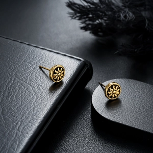 Detailed macro view of vintage gold sunburst earrings featuring intricate relief pattern