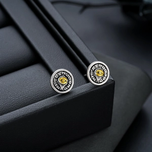 Vintage silver and gold Eye of Providence stud earrings on a black leather jewelry box