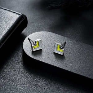 Modern two-tone geometric triangle stud earrings with lime green and white enamel finish