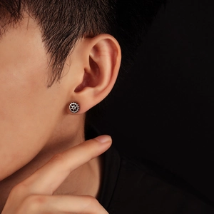 Close-up of industrial punk gear stud earrings in matte silver finish on a model's ear