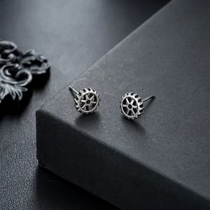 Macro shot of industrial gear-shaped earrings with vintage metallic texture and detail
