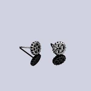 Industrial style gear-shaped stud earrings in vintage silver with a mirror reflection