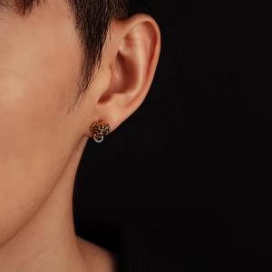 Vintage Chinese lion head stud earrings with gold and silver accents on model