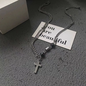 Gros plan d'un collier double épaisseur en argent style industriel avec croix