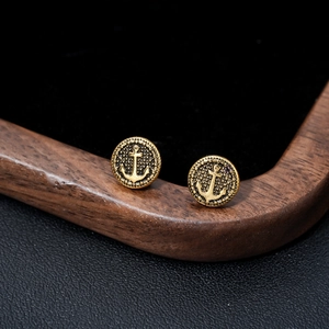 Golden round anchor stud earrings with textured rim shown from a 45-degree angle