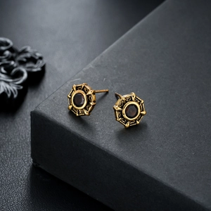 Macro shot of vintage bronze star stud earrings with a deep red center gemstone