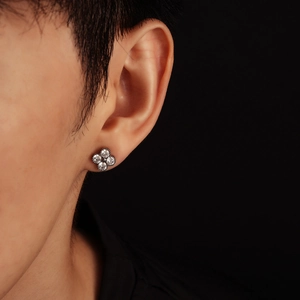Elegant four-leaf clover stud earring with sparkling cubic zirconia on model's ear