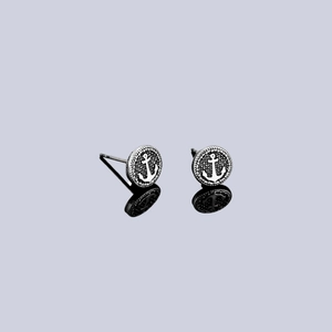 Silver vintage anchor stud earrings with rope texture on a reflective surface