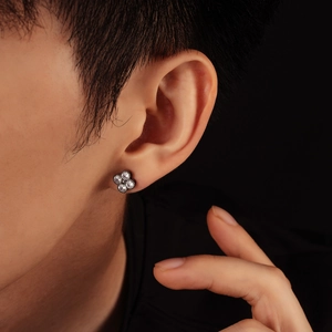 Close-up of four-leaf clover earring with clear crystals on black metal plating
