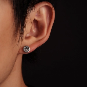 Macro detail of retro round sun totem stud earring in oxidized 925 sterling silver