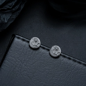Macro shot of vintage sun and eagle pattern on gunmetal stud earrings for men