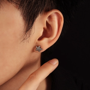 Close-up of a vintage silver starfish stud earring on a model with detailed metallic texture