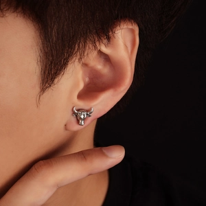 Close-up of vintage silver bull head magnetic earring with detailed relief carving