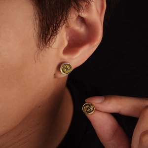 Vintage dragon relief stud earrings in two-tone metal finish worn on male model ear