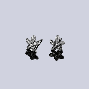 Macro view of starfish earrings featuring vintage textures and oxidized silver finish