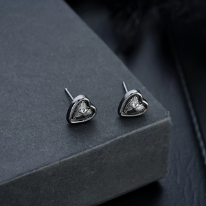 Detail shot of vintage gothic heart earrings with star cross texture on jewelry box