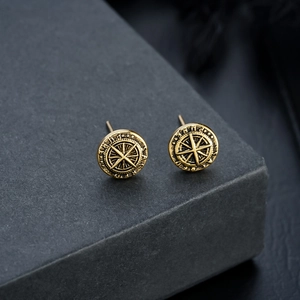 Nahaufnahme der Vintage-Goldstern-Kompass-Ohrstecker mit gravierten Buchstaben-Details