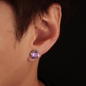 Detail of silver Mobius magnetic clip-on earring with purple cat-eye stone on ear