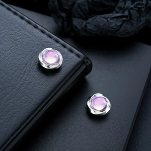 Detail shot of Mobius cat-eye magnetic earring with purple stone on black leather