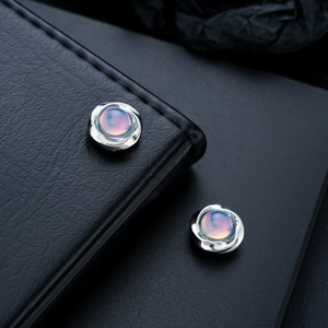 Close-up of Mobius cat-eye magnetic stud earrings with molten silver texture
